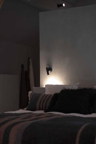 a bedroom with a bed with a light on the wall at Chambres de Gilberoux in Floreffe