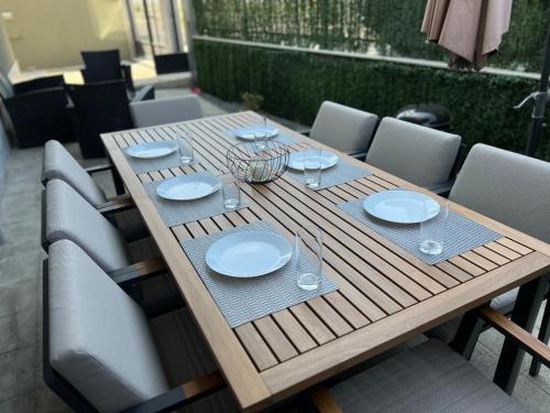 a wooden table with plates and wine glasses on it at Hilton Burgas Holiday Home in Burgas City