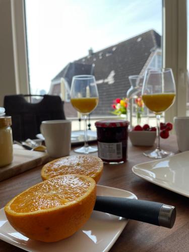 a table with two slices of bread and two glasses of wine at Ferienwohnung Dünenbutze in Büsum