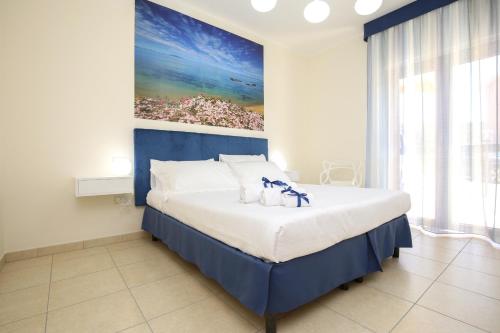sypialnia z dużym łóżkiem z obrazem na ścianie w obiekcie Swimming Pool and Relax Apartment w mieście Castelsardo