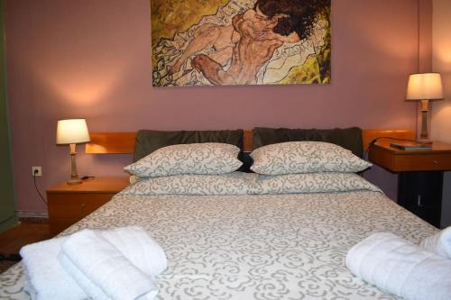 sypialnia z łóżkiem z 2 poduszkami i obrazem w obiekcie Bellissimo w mieście Alepou