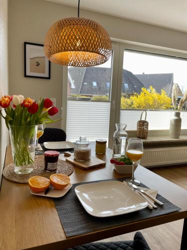 a table with a plate of food and a glass of wine at Ferienwohnung Dünenbutze in Büsum