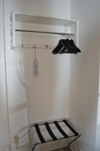 a metal chair in a white room with a shelf at Lilla Hotellet Bed & Breakfast i Alingsås in Alingsås