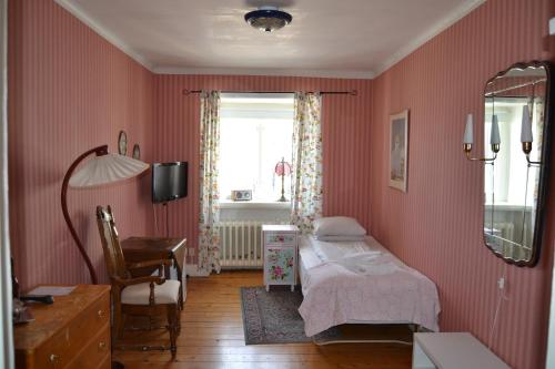 a bedroom with a bed and a desk and a window at Lilla Hotellet Bed & Breakfast i Alingsås in Alingsås