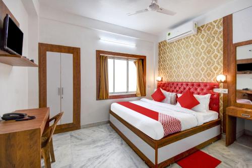 a hotel room with a bed and a desk at OYO Diamond Plaza Near Acropolis Mall in Jādabpur