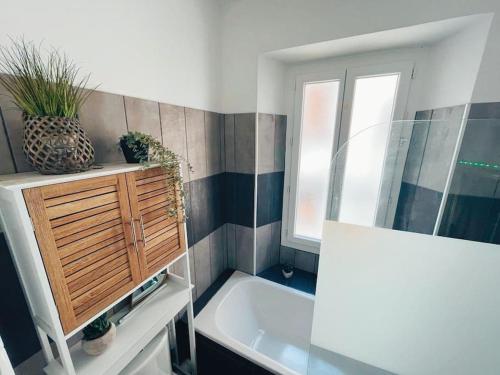 une salle de bain avec une baignoire et une fenêtre dans l'établissement Grand appartement cosy lumineux, à Saint-Maximin-la-Sainte-Baume