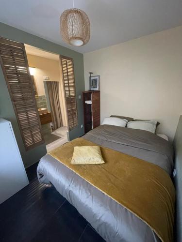 Un dormitorio con una cama con una manta de oro. en Le clos de Marissel en Beauvais