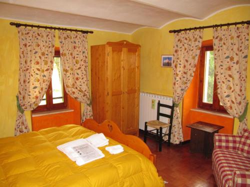 een slaapkamer met een geel bed en een stoel bij Masseria Cerasella in Pescocostanzo