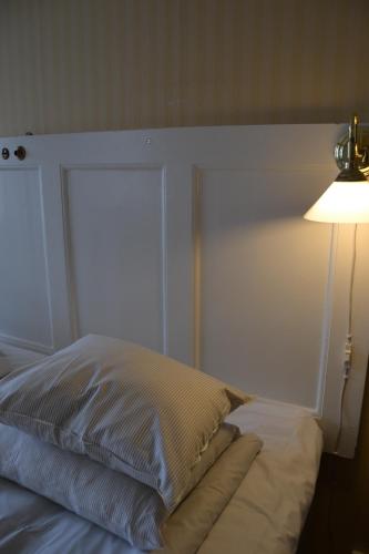 a bedroom with a bed with a lamp next to it at Lilla Hotellet Bed & Breakfast i Alingsås in Alingsås