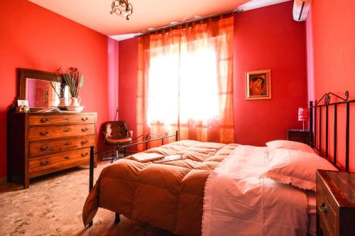 una camera da letto con pareti rosse, un letto e una finestra di B&B Casa Fuori Casa 200 mt dal casello autostradale a Senigallia