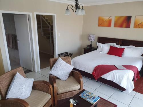 a bedroom with a bed and a table and chairs at Ingwe Manor Guesthouse in Margate