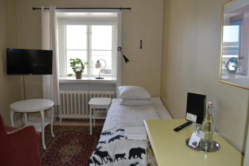 une chambre à l'hôpital avec un lit, une table et une fenêtre dans l'établissement Lilla Hotellet Bed & Breakfast i Alingsås, à Alingsås