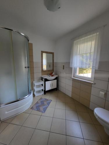 a bathroom with a shower and a sink and a mirror at Kwatery pod wieżą 