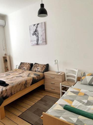 a bedroom with two beds and a desk and a lamp at Apartmani Lučin in Rijeka