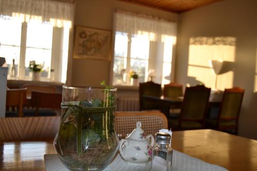 a vase with a plant in it sitting on a table at Lilla Hotellet Bed & Breakfast i Alingsås in Alingsås