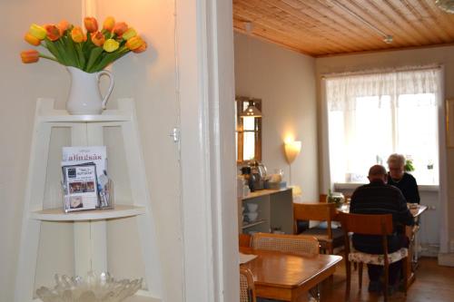 a dining room with a vase of flowers on a shelf at Lilla Hotellet Bed & Breakfast i Alingsås in Alingsås