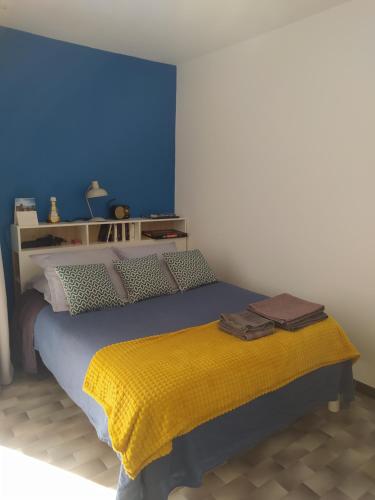 1 dormitorio con 1 cama con manta amarilla en Jolie studio 2 étoiles proche de l'étang de thau, en Balaruc-les-Bains