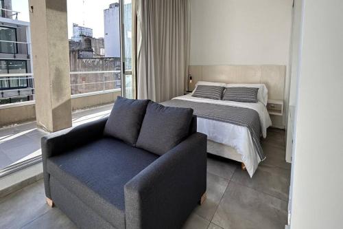 1 dormitorio con cama, sofá y ventana en AREN0702 Excelente gran Depto en Barrio Norte en Buenos Aires