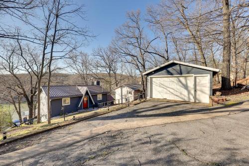 a house with a garage on the side of a road at Deck, Fire Pit and Grill Lakefront Oklahoma Abode in Jay