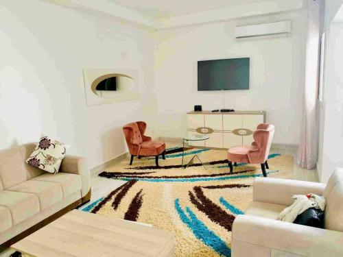 a living room with a couch and a table and chairs at Terranga et douceur aux almadies in Dakar
