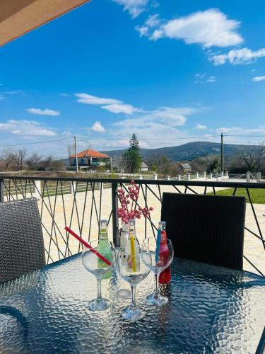 a table with two wine glasses and flowers on it at Villa Hirundinidae in Gornji Muć