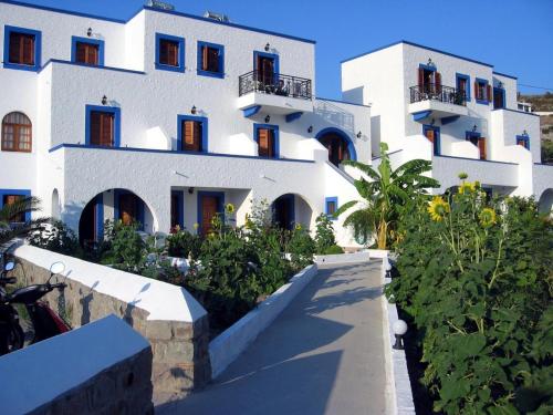 a large white building with a bunch of plants at Nicolas Studios in Skala