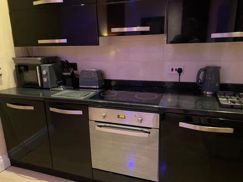a kitchen with a stove and a counter top at The Penthouse at Ty Gwyn in Llandudno