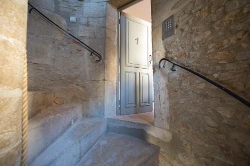 un escalier doté d'une porte et d'une cloison d'escalier. dans l'établissement Maison du colombier, à Beaune