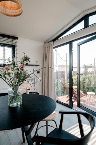 a dining room with a black table and a large window at B-LESS in Blankenberge