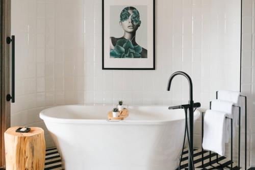 a white bath tub in a bathroom with a picture at Delta Hotels by Marriott Vancouver Downtown Suites in Vancouver