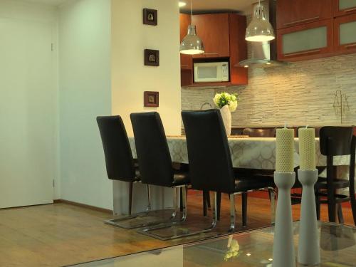 a dining room with a table and black chairs at Penzión Florens, Nesvady in Nesvady