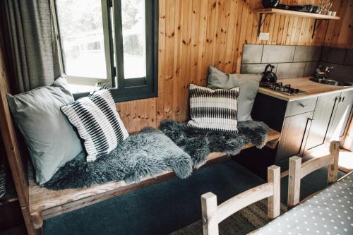 una habitación con sofás y almohadas en una casa pequeña en Swaledale Shepherd's Hut en Newton Abbot