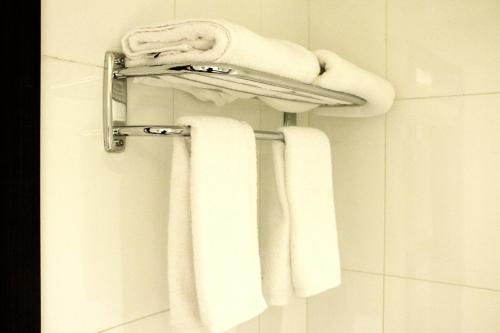a bathroom with white towels on a towel rack at Business Inn Olaya in Riyadh
