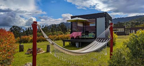 a hammock in front of a tiny house at Iraca Glamping in Guatavita