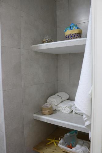 een badkamer met handdoeken op planken in een douche bij Duplex Avenida in Tarifa