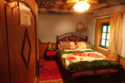 1 dormitorio con cama y ventana en Tigmino Maison D'or en Tafraoute