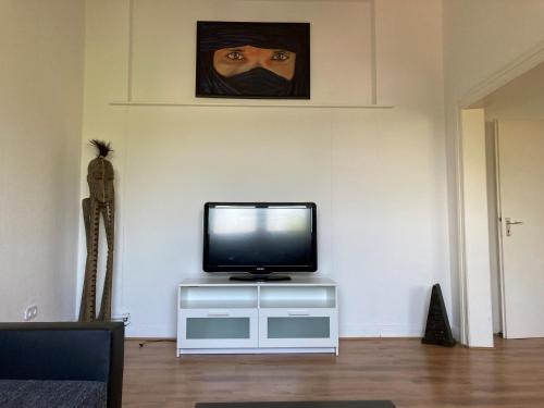 a tv sitting on a stand in a living room at gemütliche Altbauwohnung im Wuppertaler Westen in Wuppertal