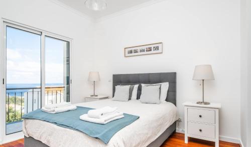 a bedroom with a bed with a view of the ocean at Villa Ana D'Arfet in Água de Pena