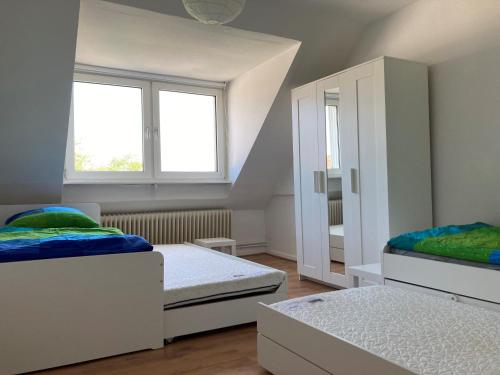 a bedroom with two beds and a cabinet at gemütliche Altbauwohnung im Wuppertaler Westen in Wuppertal