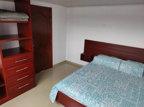 Un dormitorio con una cama y un armario de madera. en Apartamento en el Corazón de Paipa., en Paipa