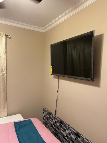 a flat screen tv on the wall of a bedroom at Don cozy in Saint Albans