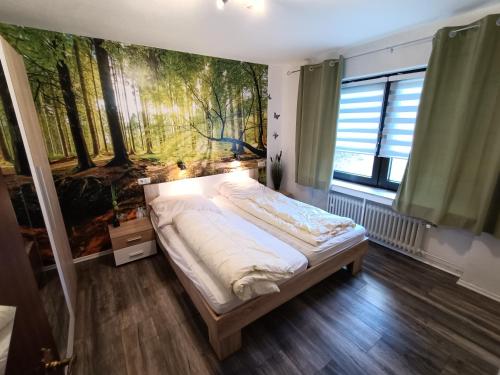 ein Schlafzimmer mit einem Bett und einem Gemälde an der Wand in der Unterkunft Landhaus Dahlem in Hahnenklee-Bockswiese