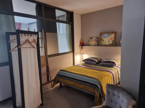 une petite chambre avec un lit et une fenêtre dans l'établissement Boulogne-sur-Mer : très bel appartement de charme, à Boulogne-sur-Mer