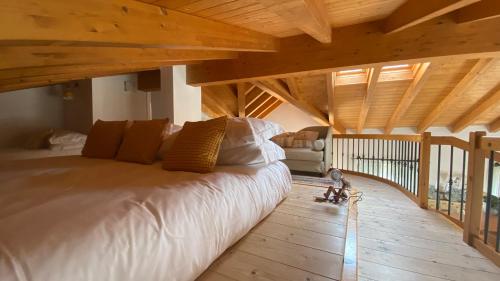 una camera con un grande letto in una stanza con soffitti in legno di Il Mulino di Hotel Villa Aurora a Nesso