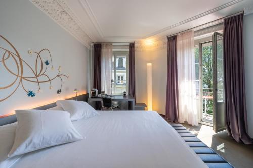 a bedroom with a large white bed and a window at BOUTIQUE Hotel by Continental Park in Lucerne