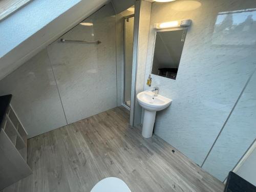 a bathroom with a sink and a toilet and a mirror at The George Hotel in Whitby