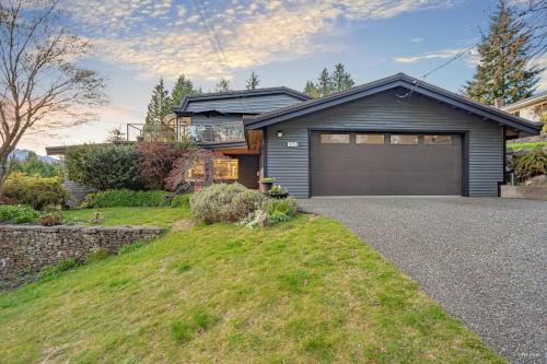 a house with a garage on the side of a driveway at Cypress: Private Bedroom/Bathroom/Office, with Shared Pool, Hot tub in North Vancouver