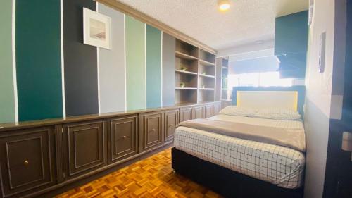 1 dormitorio con 1 cama en una habitación con rayas azules y verdes en Allegro Polanco, en Ciudad de México