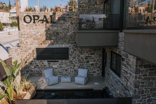 - deux chaises bleues assises sur une terrasse en face d'un bâtiment en briques dans l'établissement Opal Executive Suites, à Nauplie