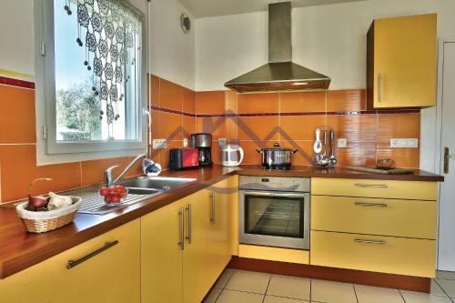 a kitchen with yellow cabinets and a sink at LocaLise - M12 - La petite Ty Marjan - Maison familiale avec jardin - A quelques pas des plages et du centre - Animaux admis - Wifi inclus - Draps inclus in Le Guilvinec